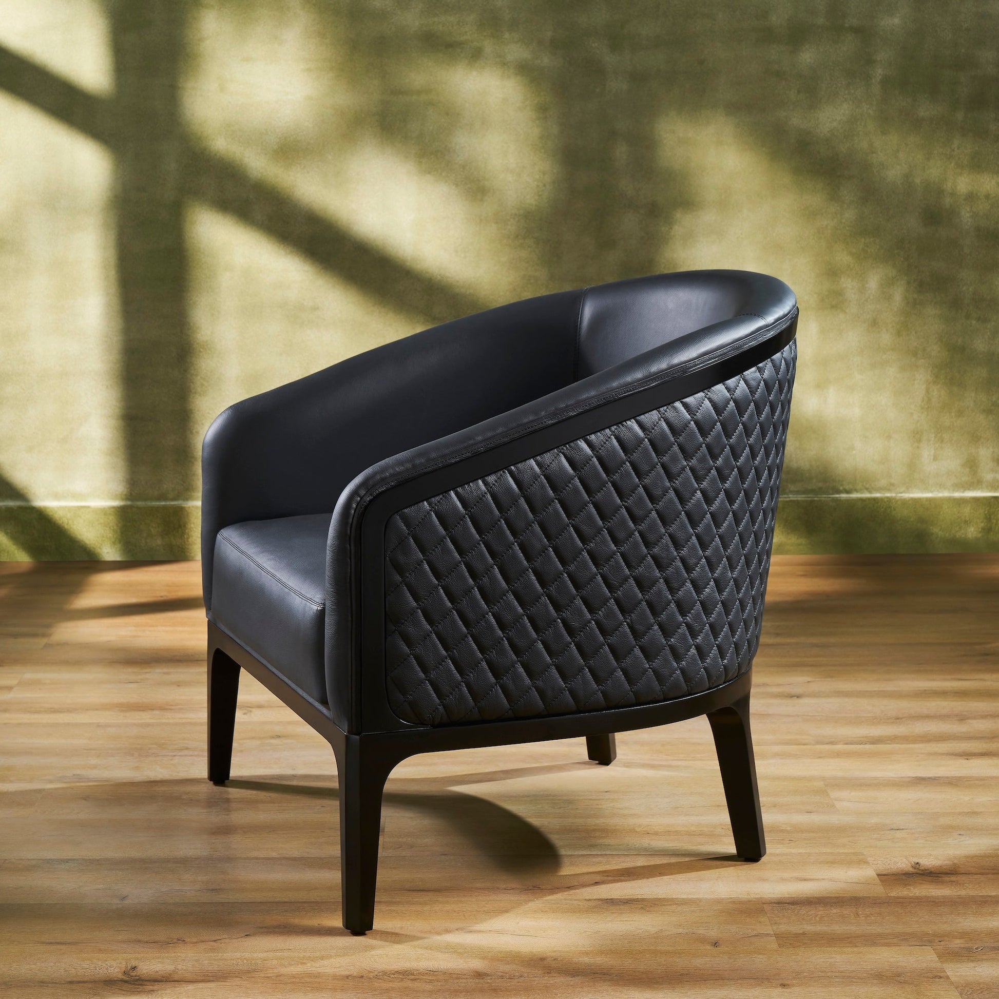 FN-5205-343329_3|Chic black leather armchair with sophisticated quilted design on side, supported by sleek dark wooden legs, for upscale interiors.