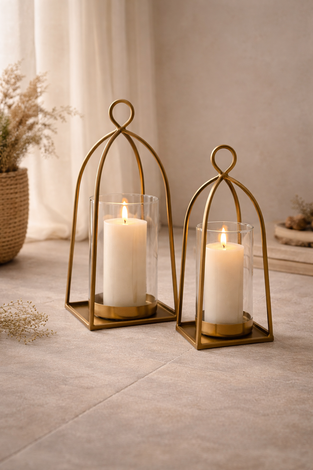 Two gold candle holders with white candles on a neutral living room
