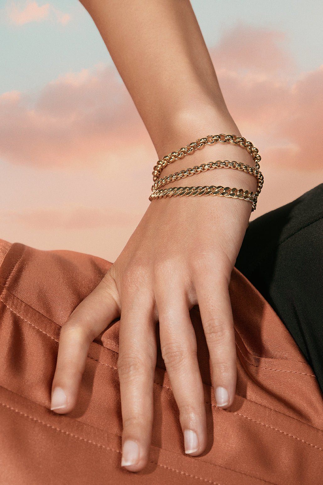 Shiny gold micro link curb chain bracelet hanging on display