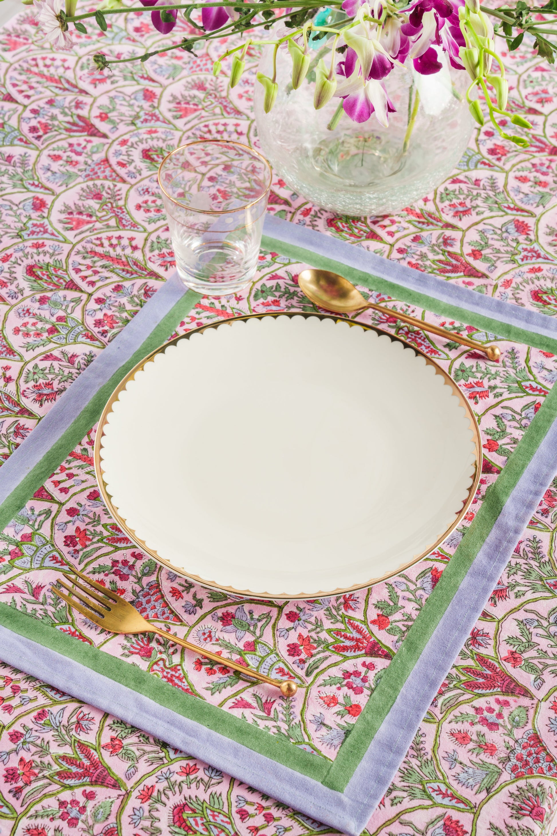 Pink arch blockprint placemat set with green borders at elegant dining scene