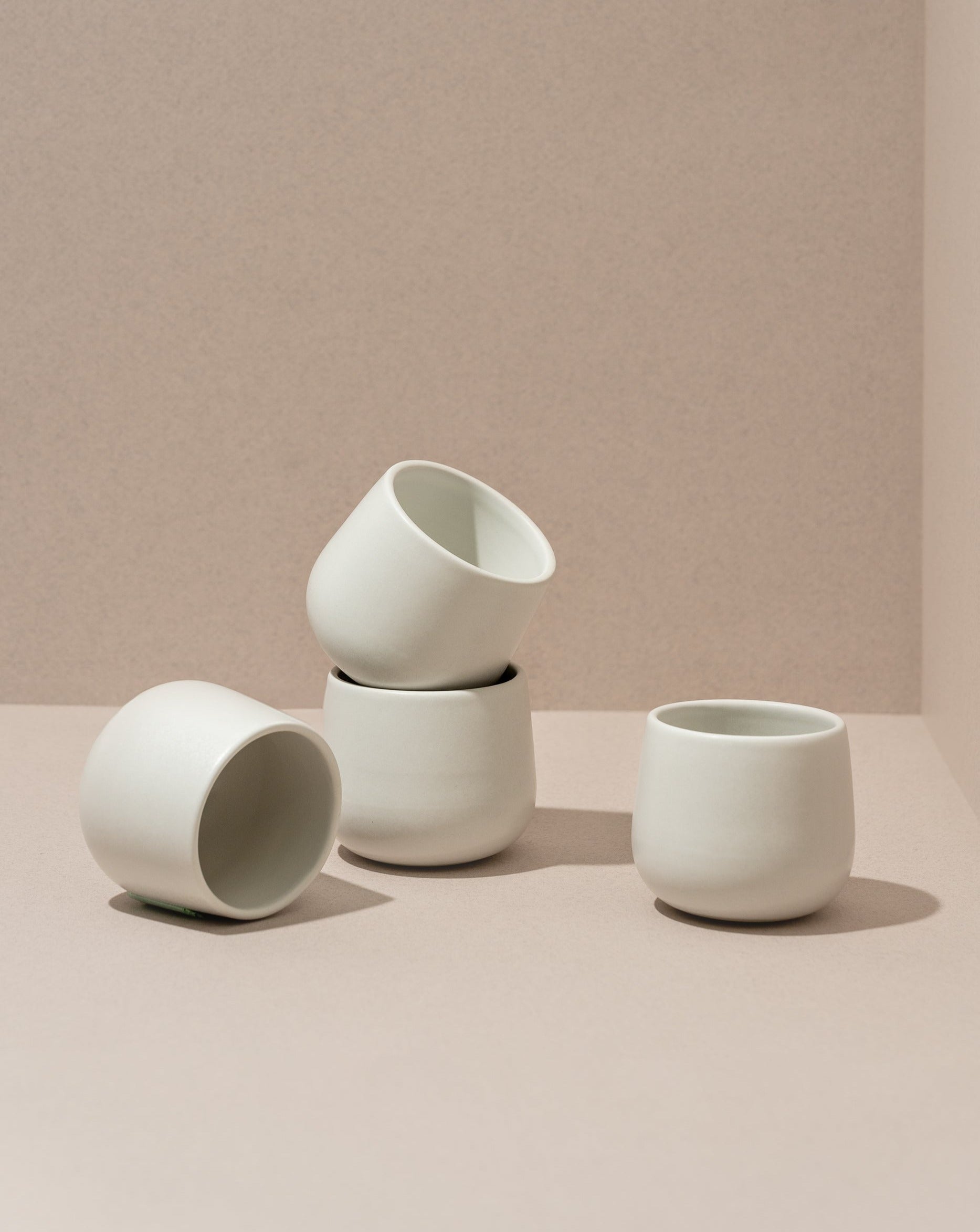 Three stoneware coffee cups in different sizes with a matte finish, displayed against a neutral background.