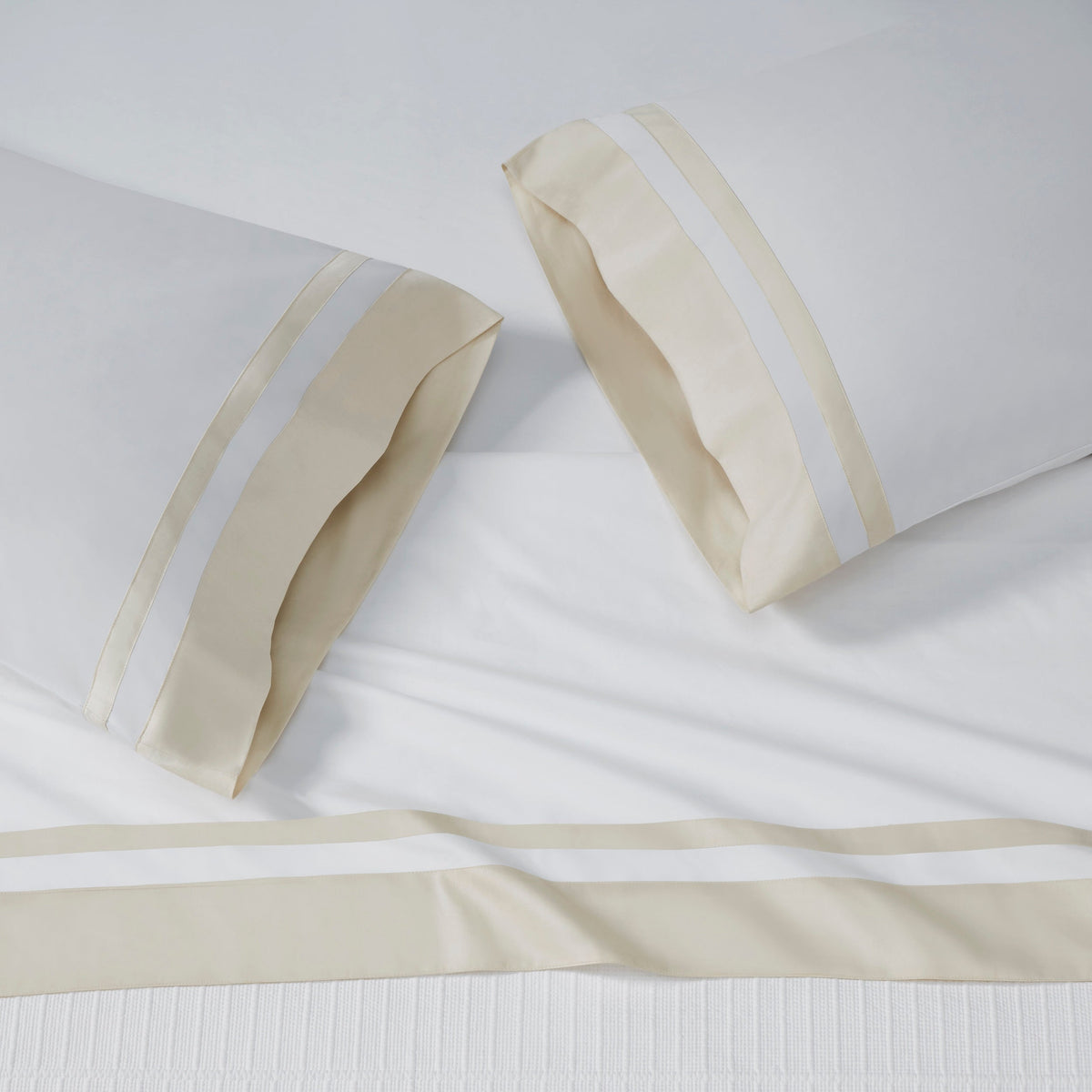 AKP-540-2040_2|White 100% cotton sateen sheet set, including two pillowcases and a flat sheet, each with wide beige and white striped borders.