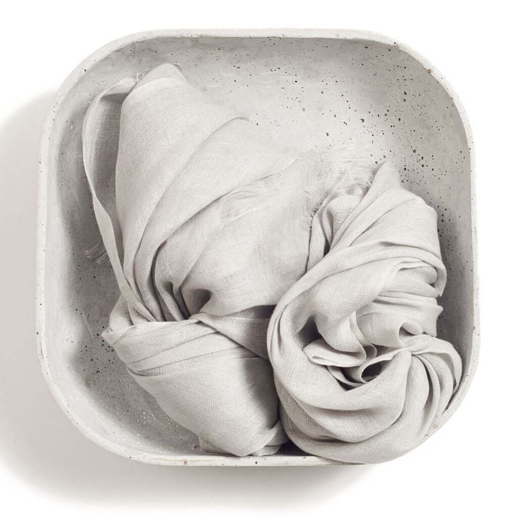 Pebble Light Gray Hand Woven Soft Linen Scarf displayed in a minimalist bowl, showcasing its elegant texture.