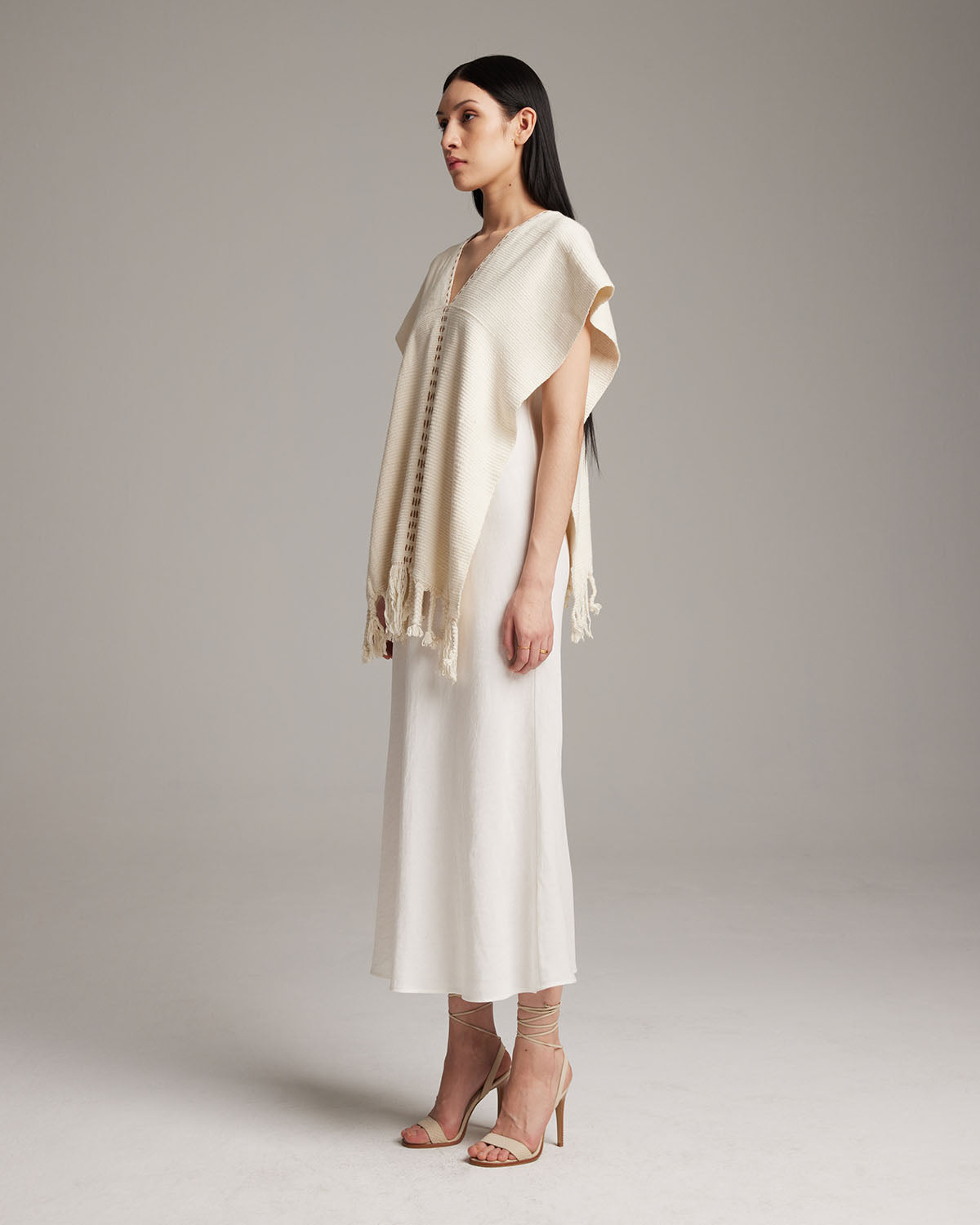 Model wearing a hand-loomed ivory Copper Threads Manta with fringe detail