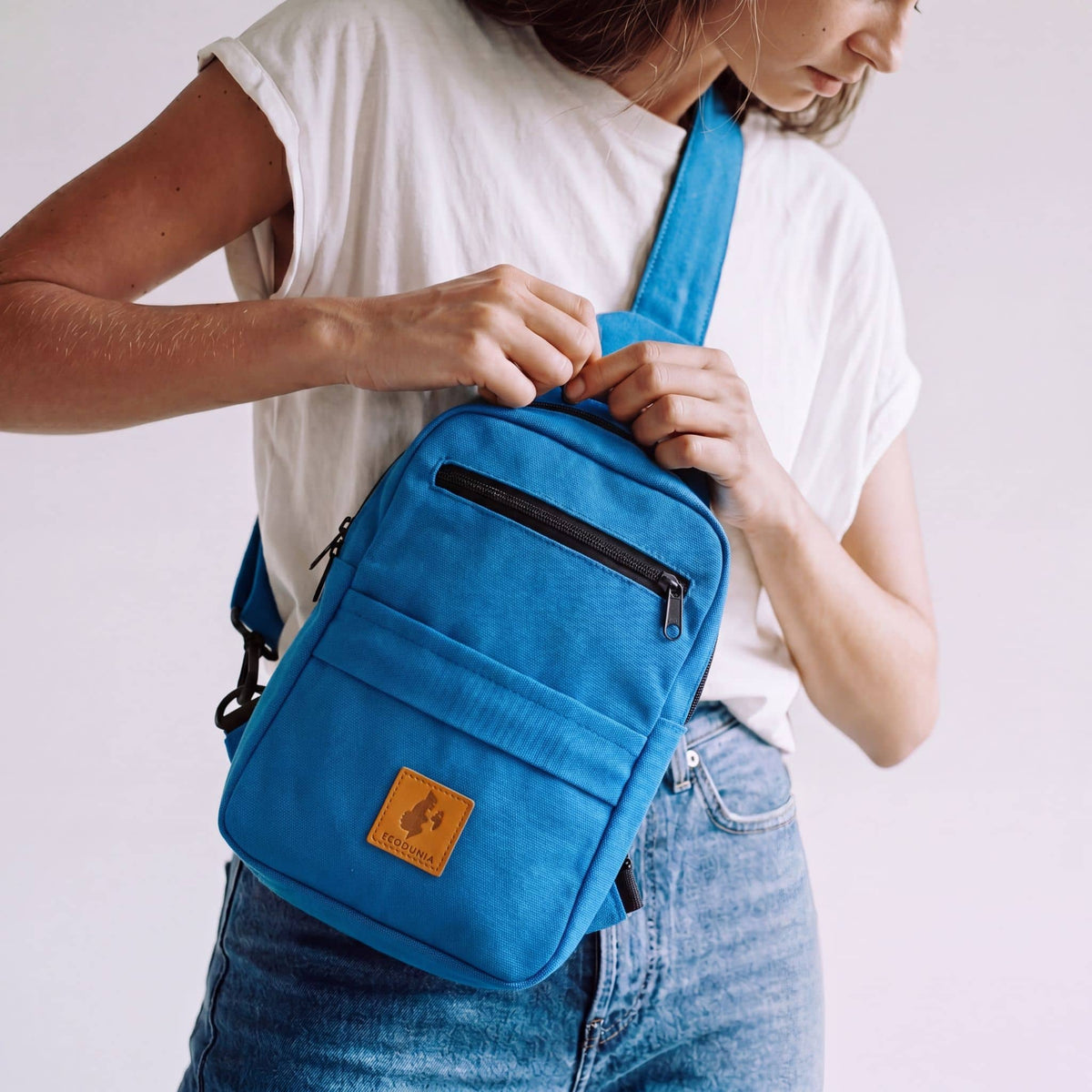 Umoja canvas sling bag in Zilly Blue worn crossbody #color_zilly-blue