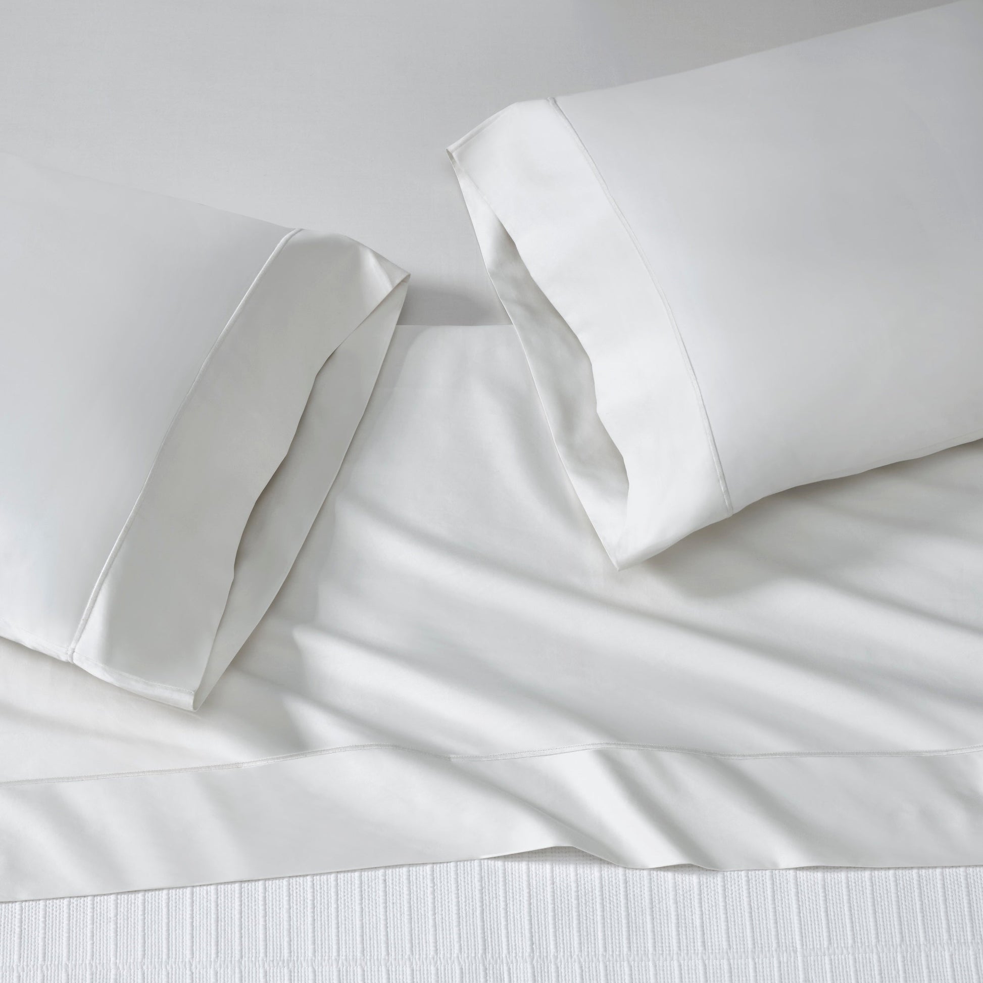 ASP-546-2032_2|White 100% cotton sateen sheet set on a bed, featuring a flat sheet and two hemmed pillowcases, smooth finish.