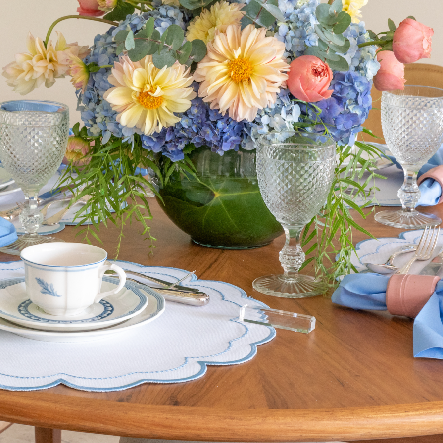 The blue Victoria impermeable placemat with Victorian-style border detail by Talah Home