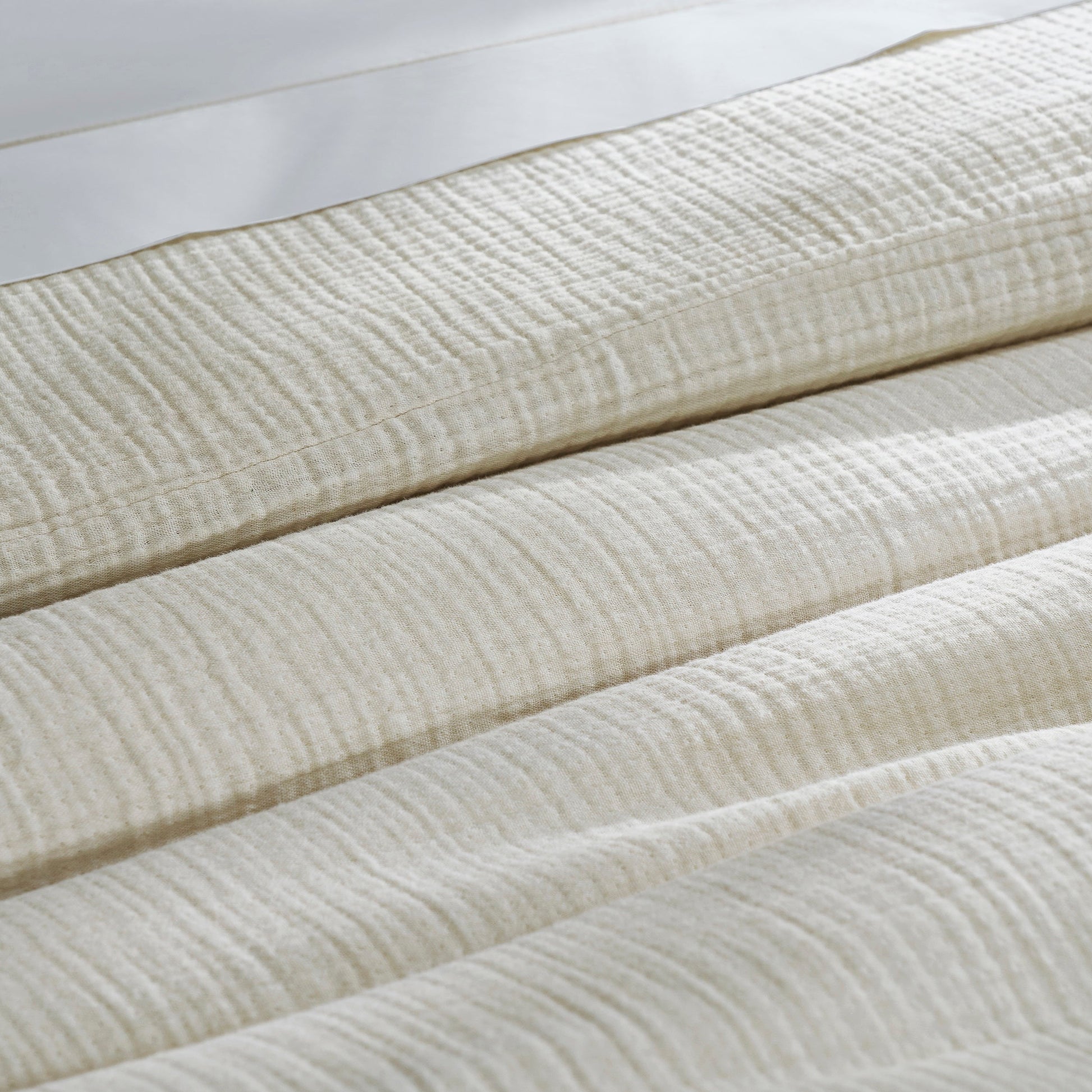 DT-049-10692_7|Folded light cream textured organic cotton gauze duvet cover, showcasing its soft, breathable, and crinkled fabric detail.