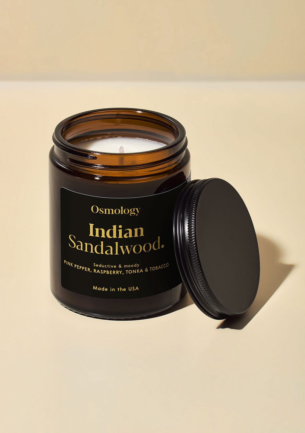 Osmology Indian Sandalwood jar candle with open lid on white background