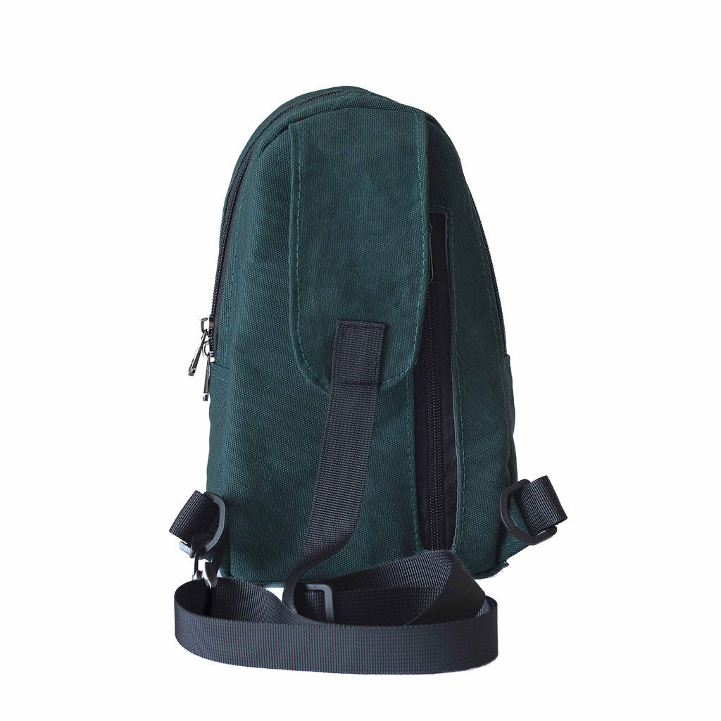 Buru canvas sling bag in forest green worn crossbody #color_forest-green