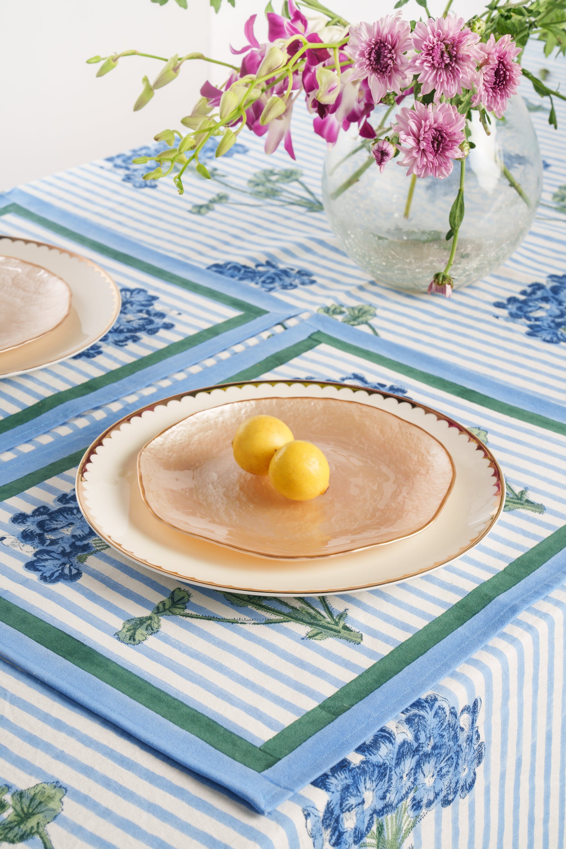 Blue striped hydrangea blockprint placemat with oval plate holding two lemons