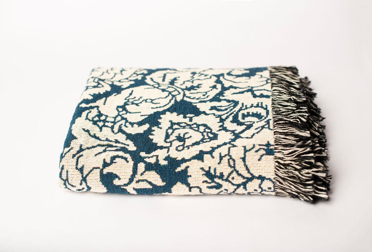 Close-up of Verona Cerulean blue and cream damask floral jacquard woven blanket with fringe