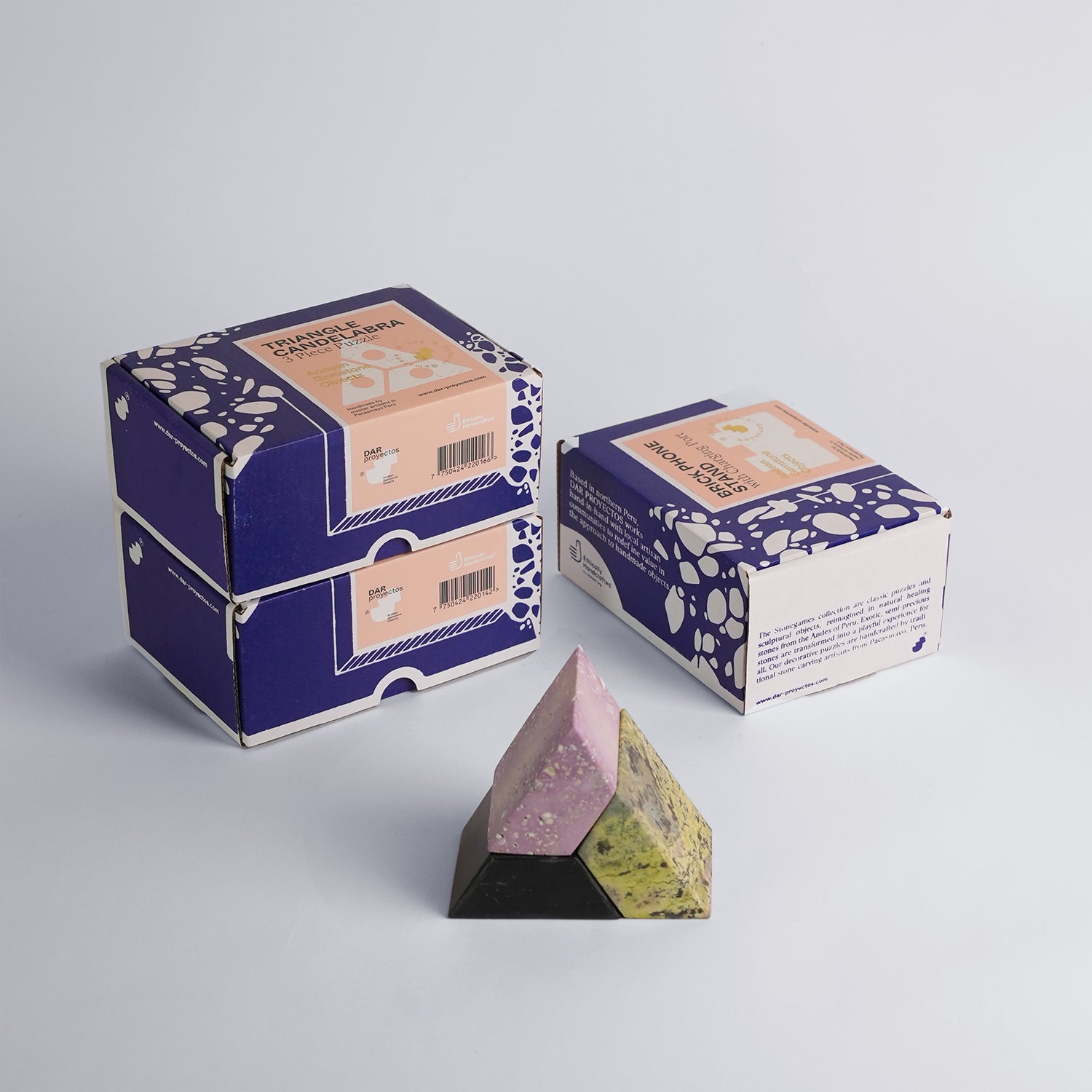 Top-down view of the handcrafted black and lilac stone candelabra blocks, highlighting their smooth matte finish and heavy Andean materiality.