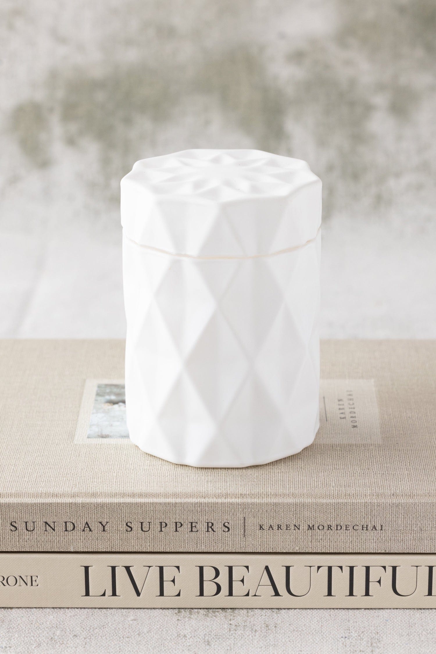 candle in a matte white glass jar with lid and diamond glass etching design