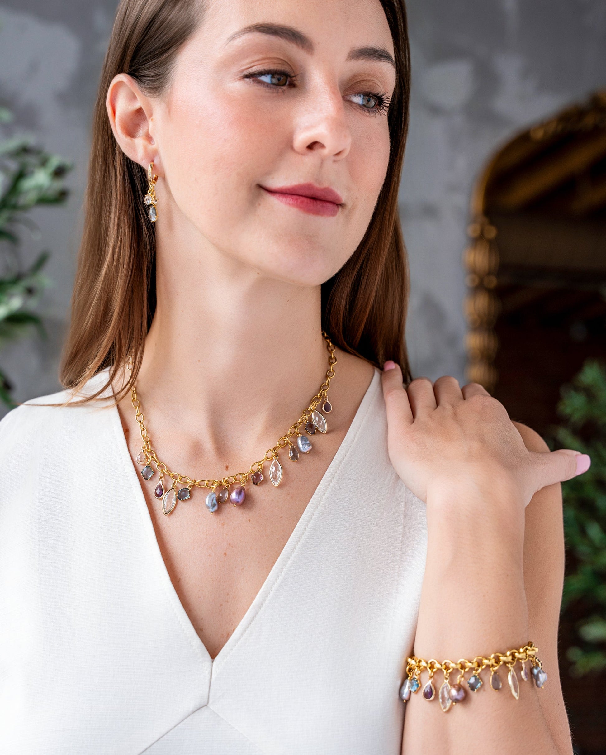 Gold chain charm bracelet with colorful faceted gemstones and iridescent freshwater pearl drops.
