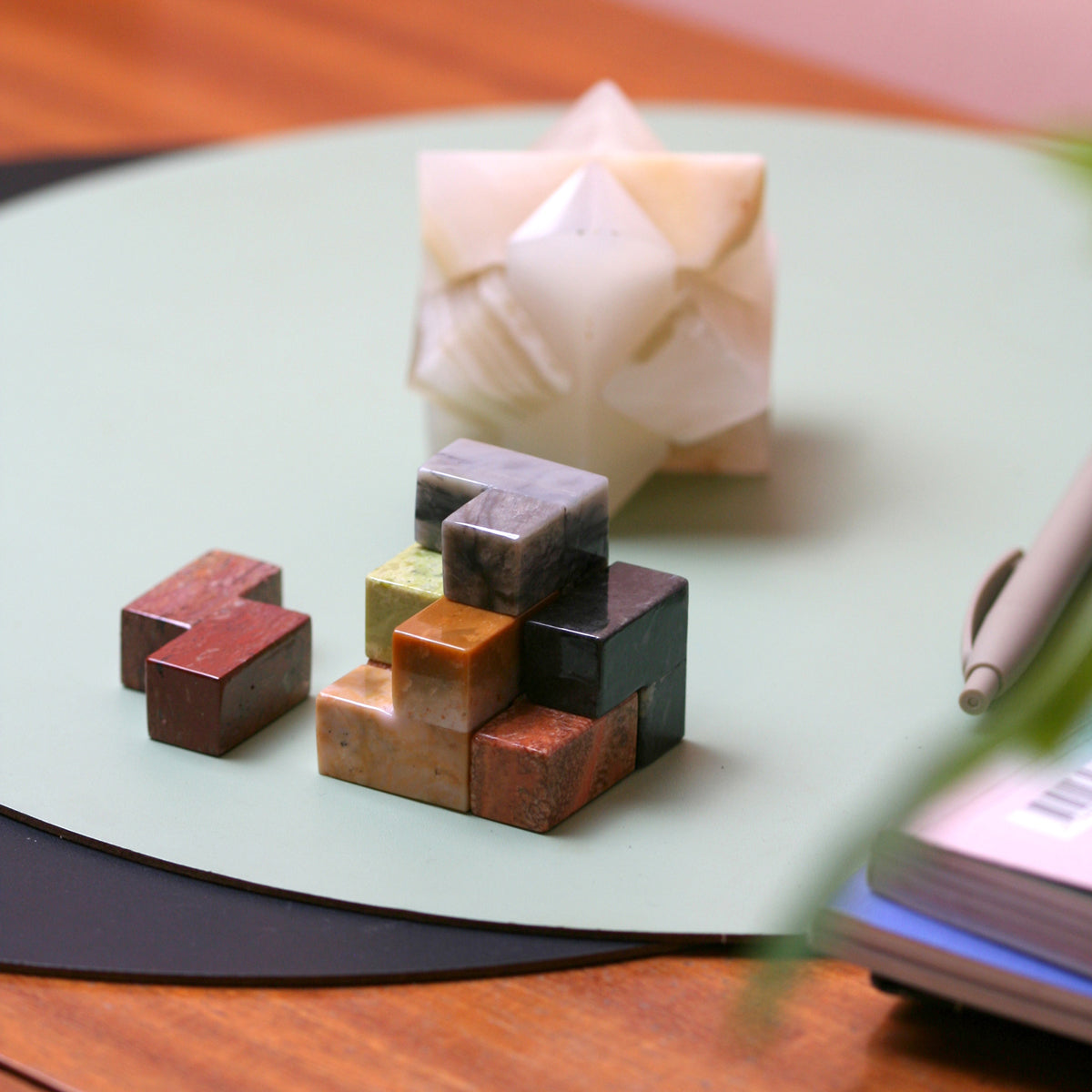 The decorative stone Soma cube puzzle resting gracefully on a wooden coffee table, acting as an elegant slow design conversation starter.