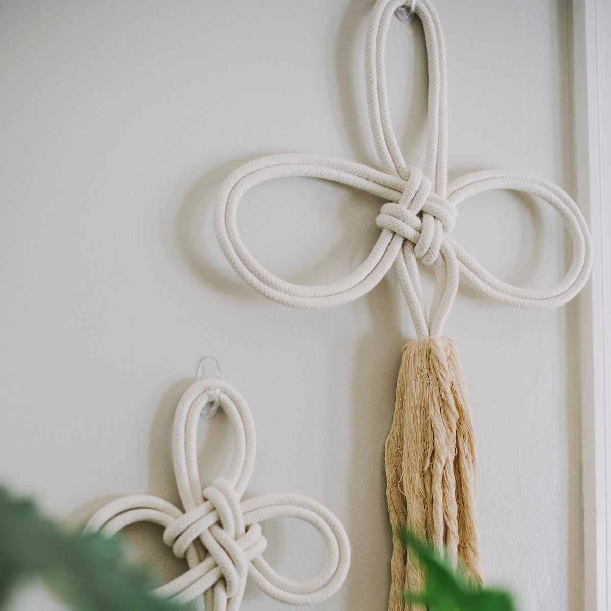 Solidarity large cream rope wall hanging above a smaller one on a white wall