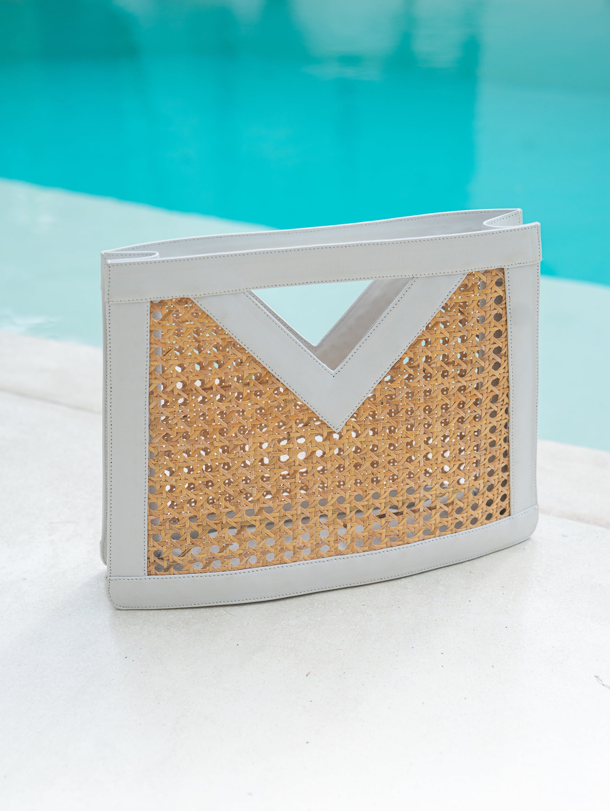 Detail up close view white leather trim and cane webbing rattan top handle tote handbag