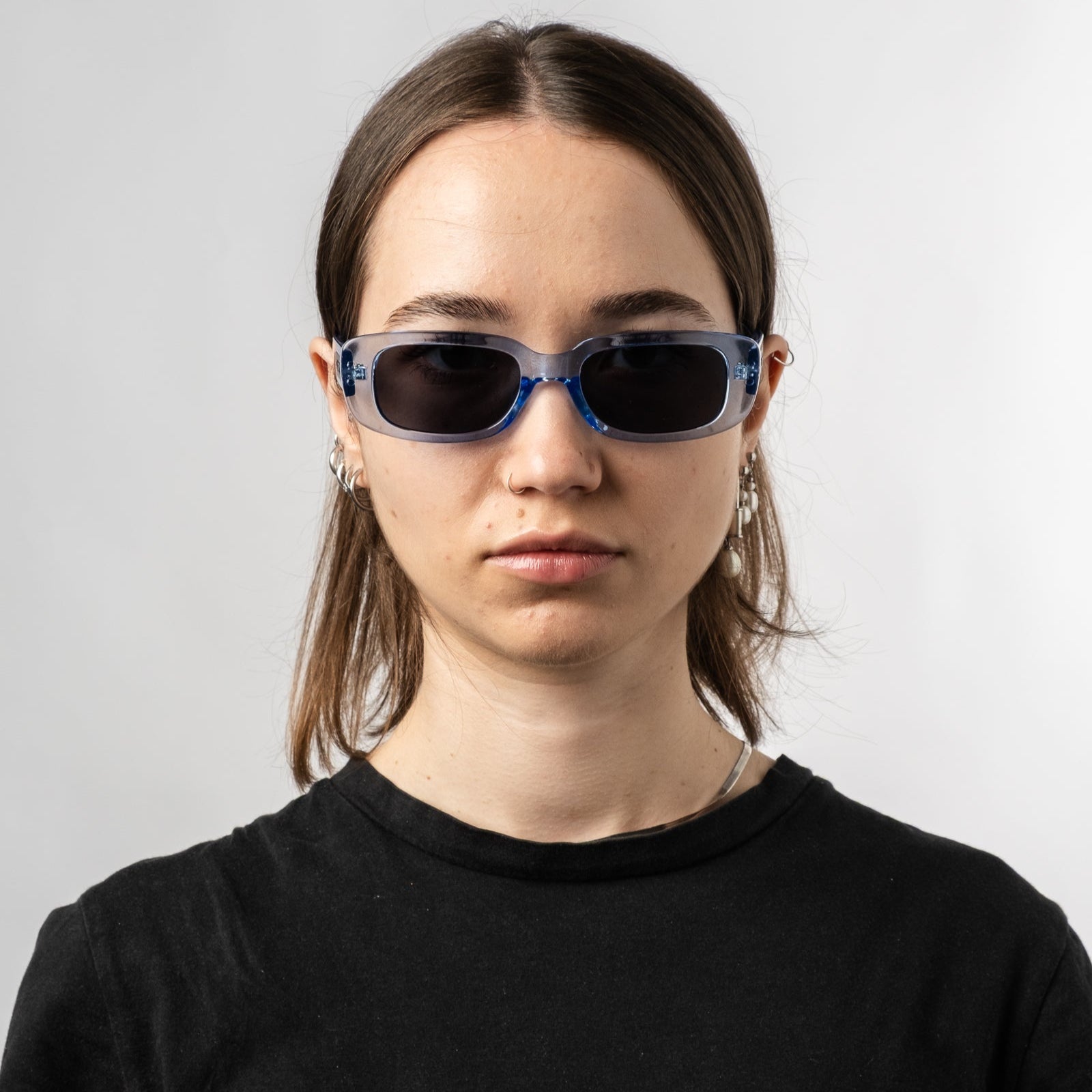 Female wearing Sad Eyewear Bouquet rectangle sunglasses in arctic blue with black tinted lenses