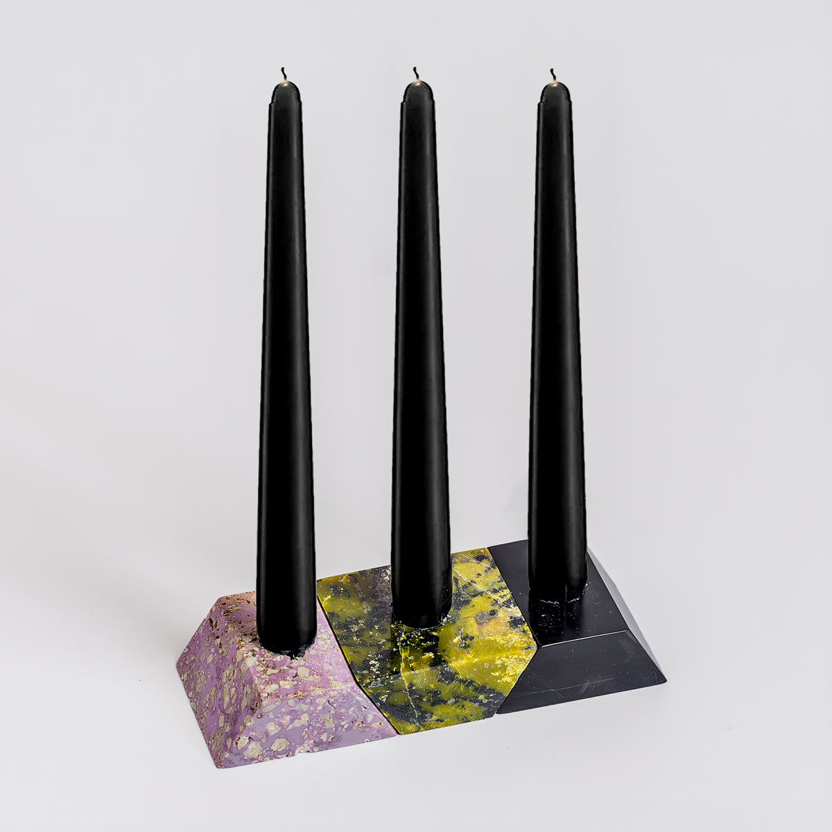 Frontal view of the disassembled lilac and black gemstone 3-piece triangle candelabra, showcasing its precise geometric carving and deep natural stone contrast on a pristine white background.