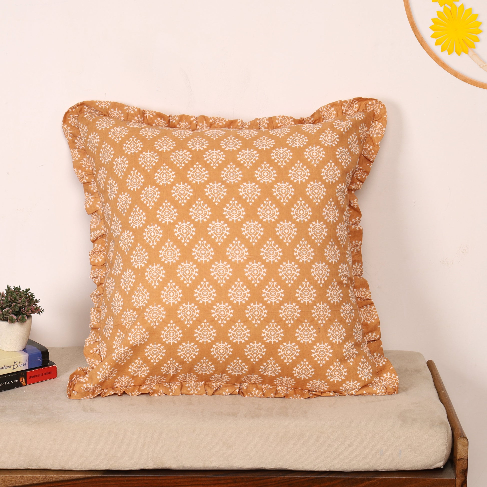 Orange block-printed ruffled pillow cover on bench