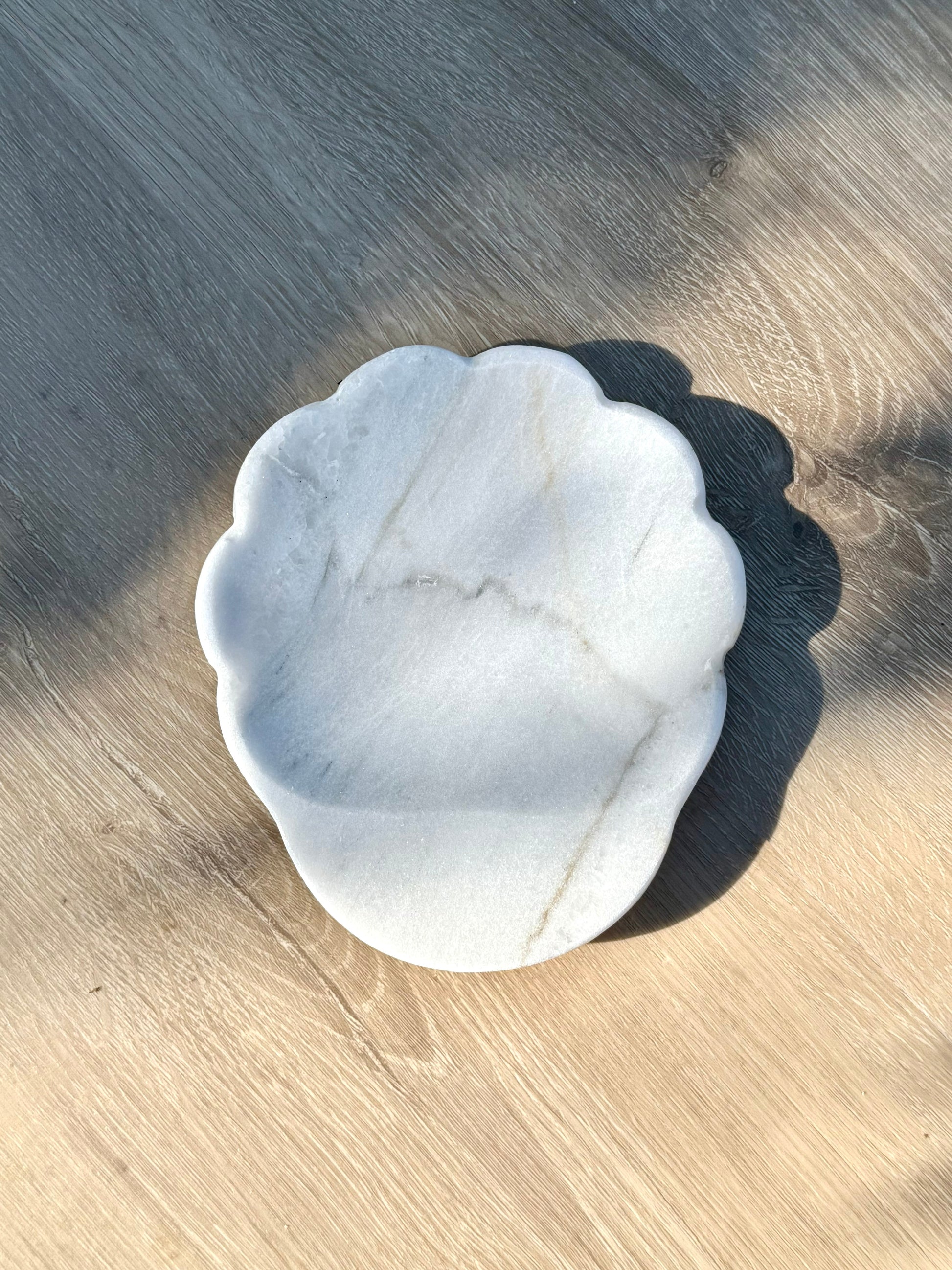 Close-up of scalloped edge detail on handcrafted white marble spoon rest