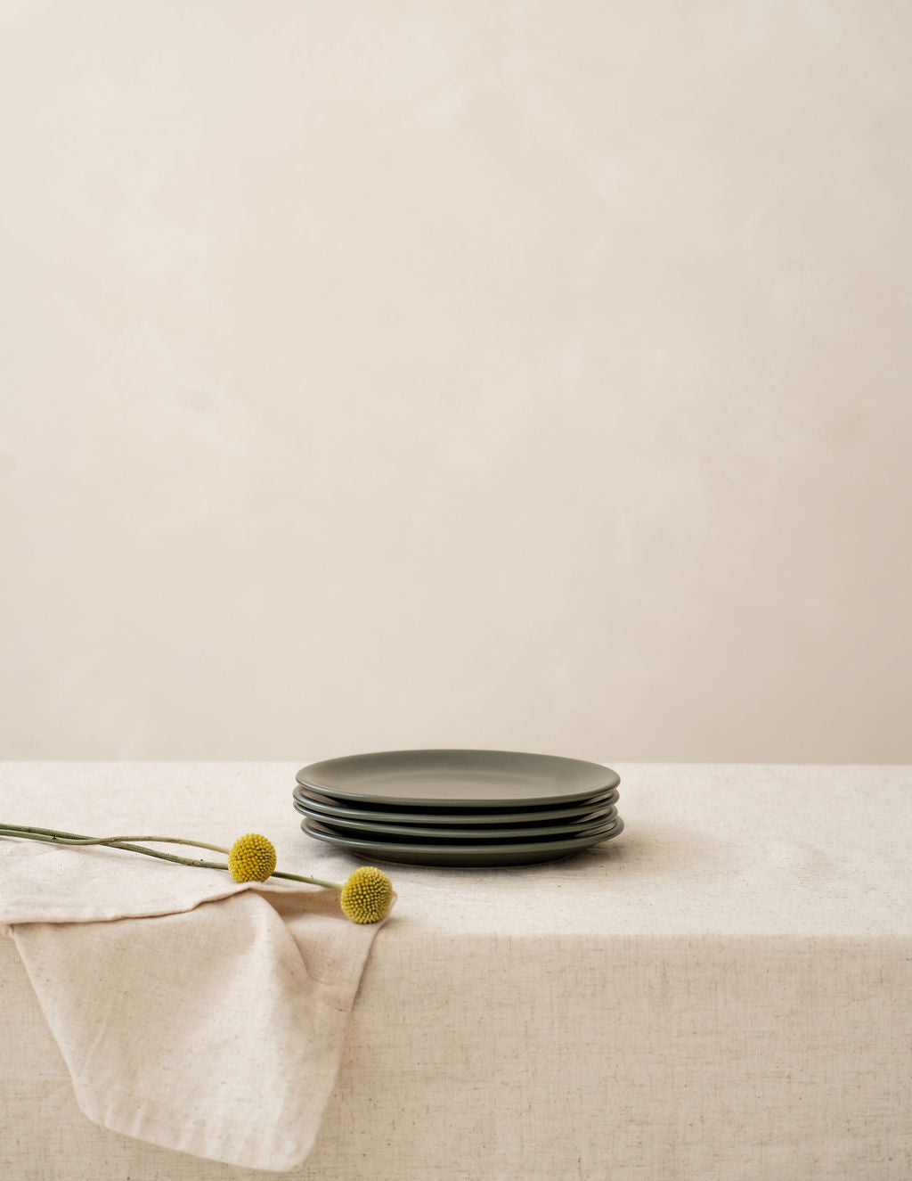 Stacked Moss green Petite side Plates by Hamkke Home on a neutral linen table.