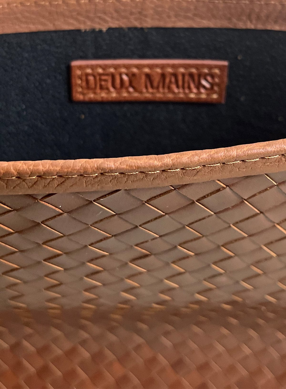 Close-up of a woven brown leather laptop case 