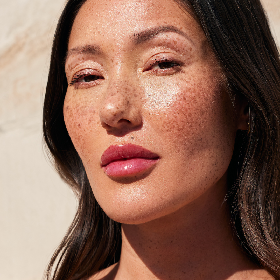 Woman wearing Côte Beauty The Necessity Peptide Lip Shine Lola Magenta Pink Non-Toxic Lip Gloss on her lips.