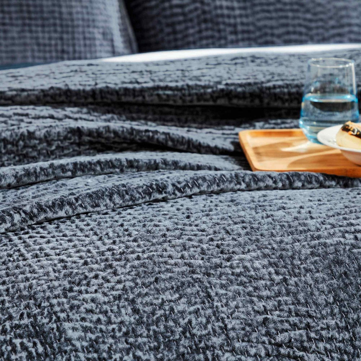CL-195-9496_6|Single navy blue textured quilted coverlet, neatly folded, offering cozy comfort and stylish layering for any bedroom.