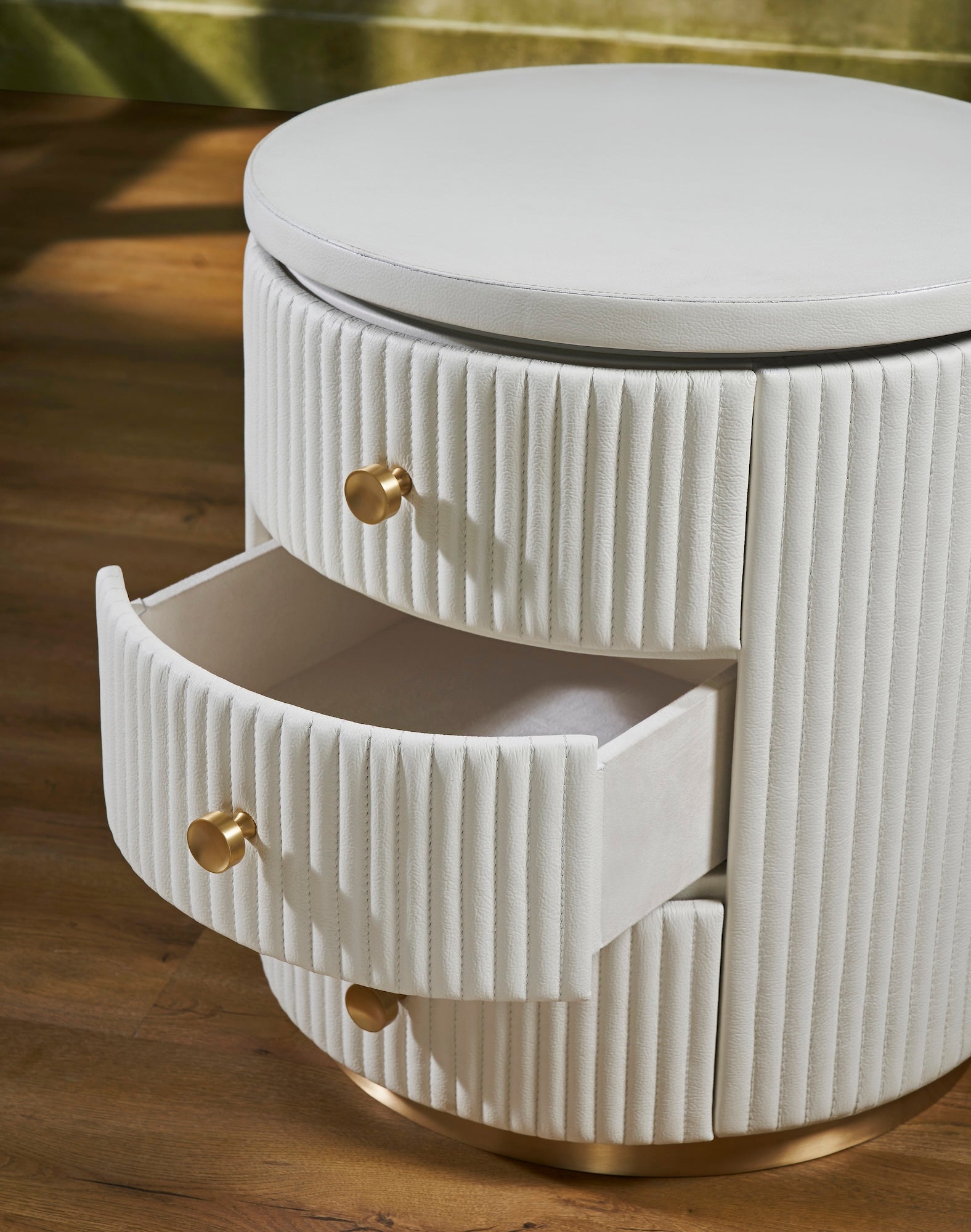 FN-5212-202022_4|Close-up of white fluted leather round nightstand with an open drawer, elegant and practical leather furniture.