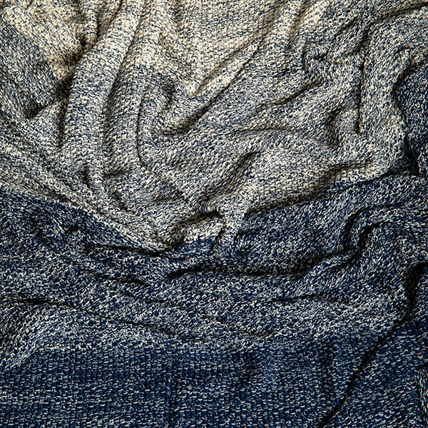 Close-up of textured blue and grey cotton throw with a focus on pattern and texture.