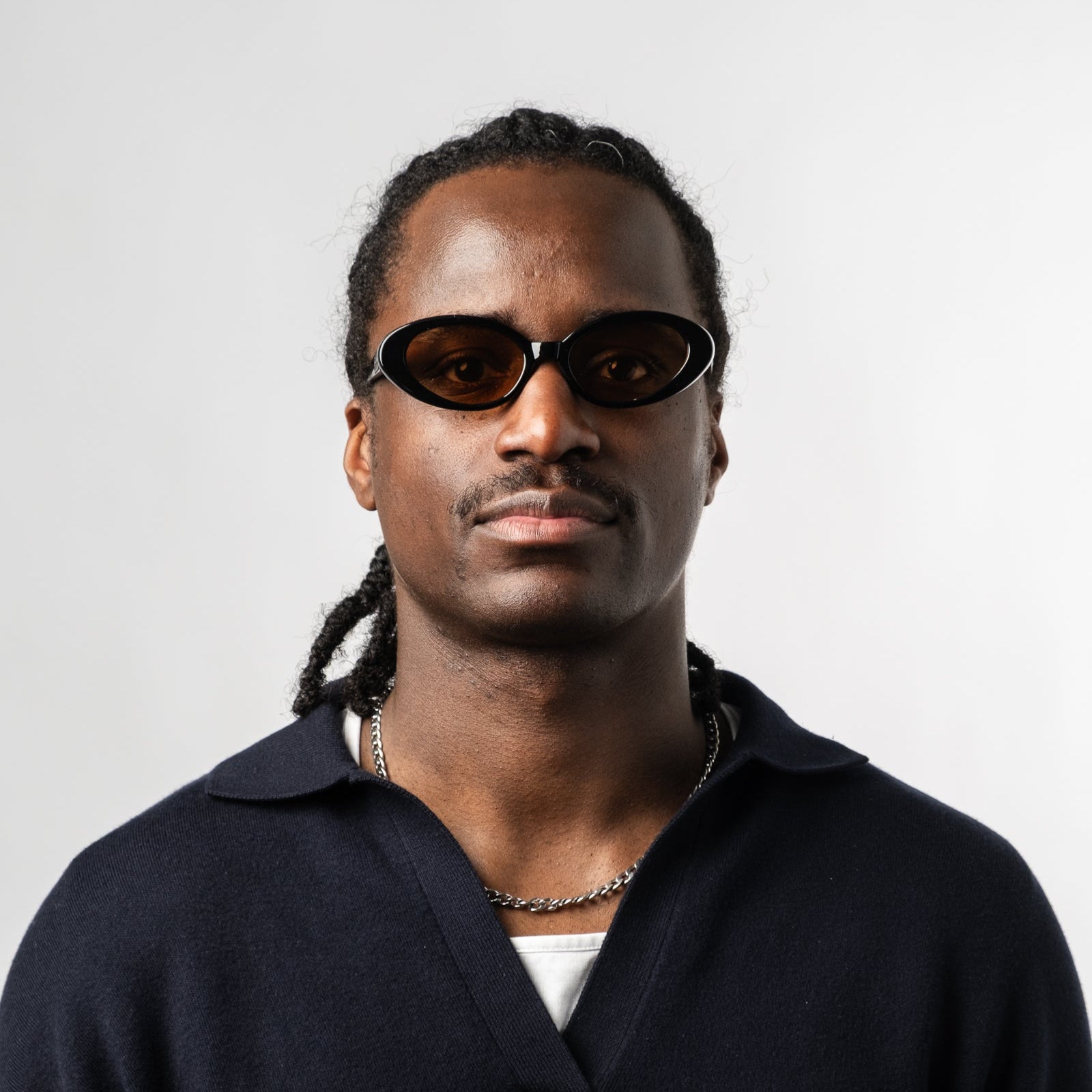 Male wearing Sad Eyewear Bloom oval sunglasses in black with tinted bronze lenses