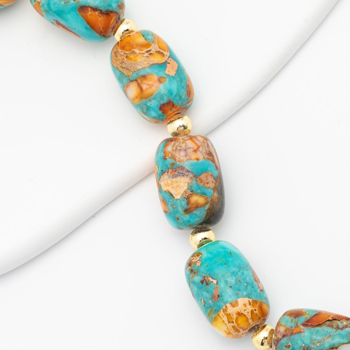 Close-up of Sierra Bloom turquoise and orange beads with gold spacers
