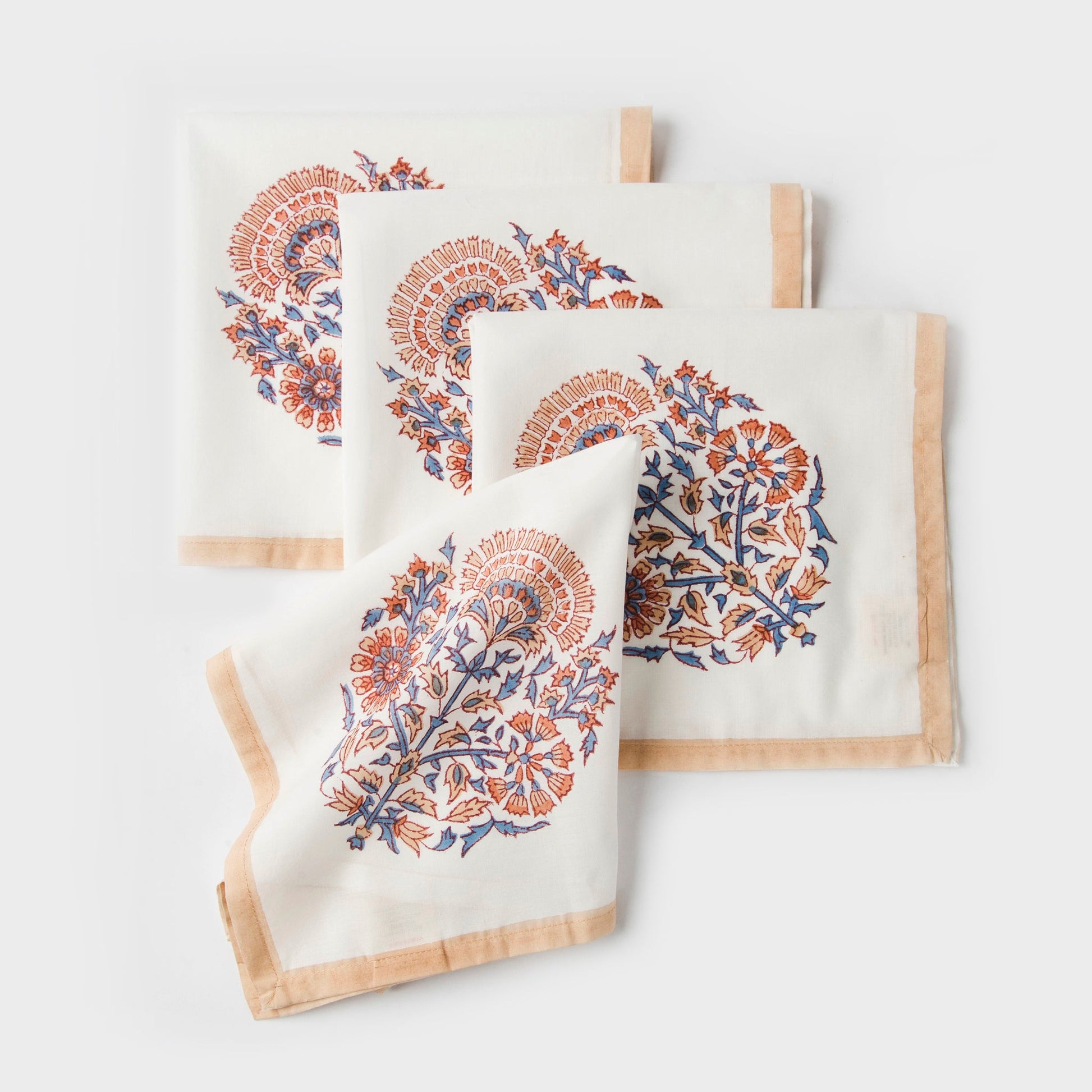 Set of 4 Saffra hand block printed cotton napkins with peach floral design and blue borders.