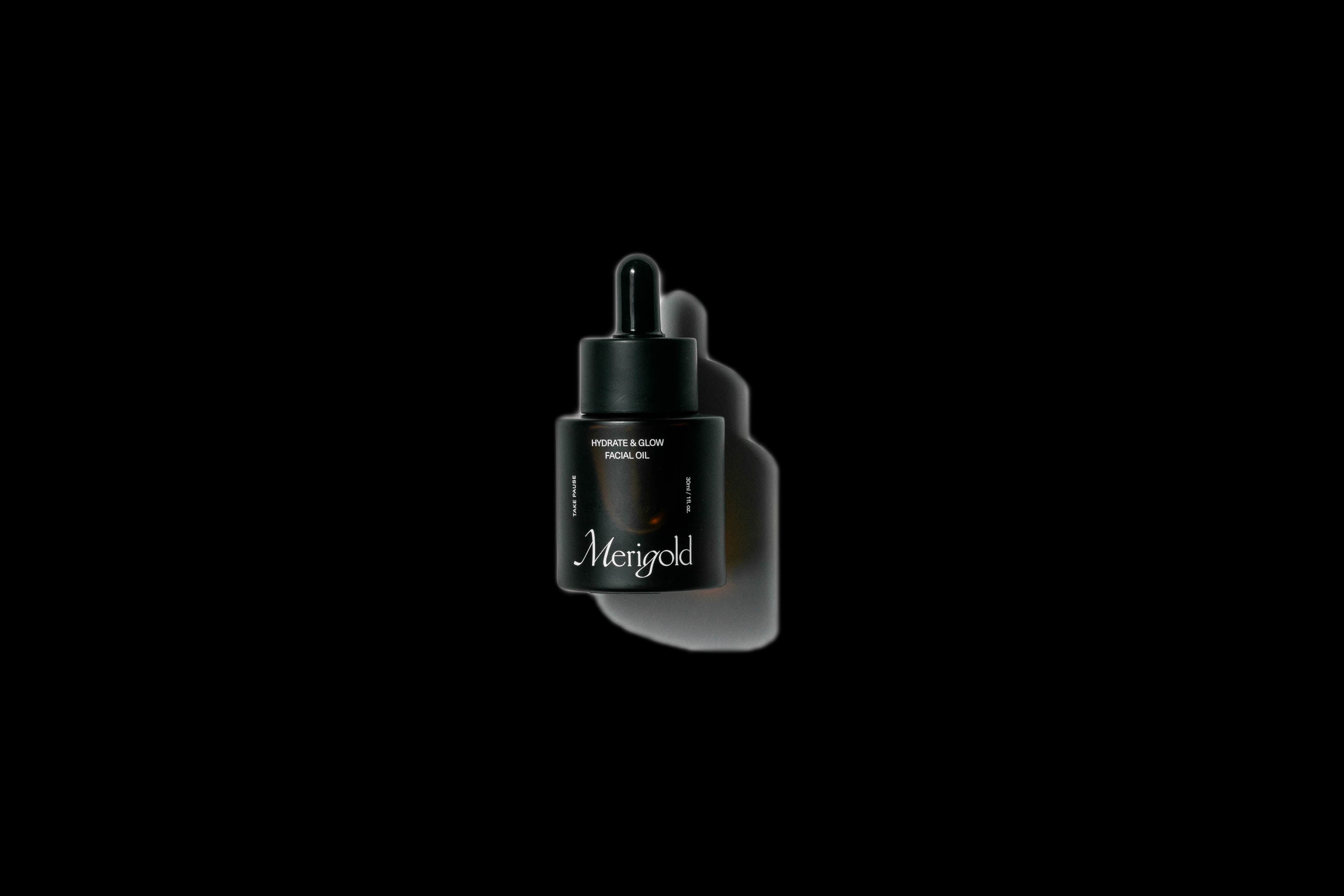 Merigold Hydrate & Glow Facial Oil in dark glass dropper bottle with shadow — antioxidant-rich, natural skincare oil for hydration