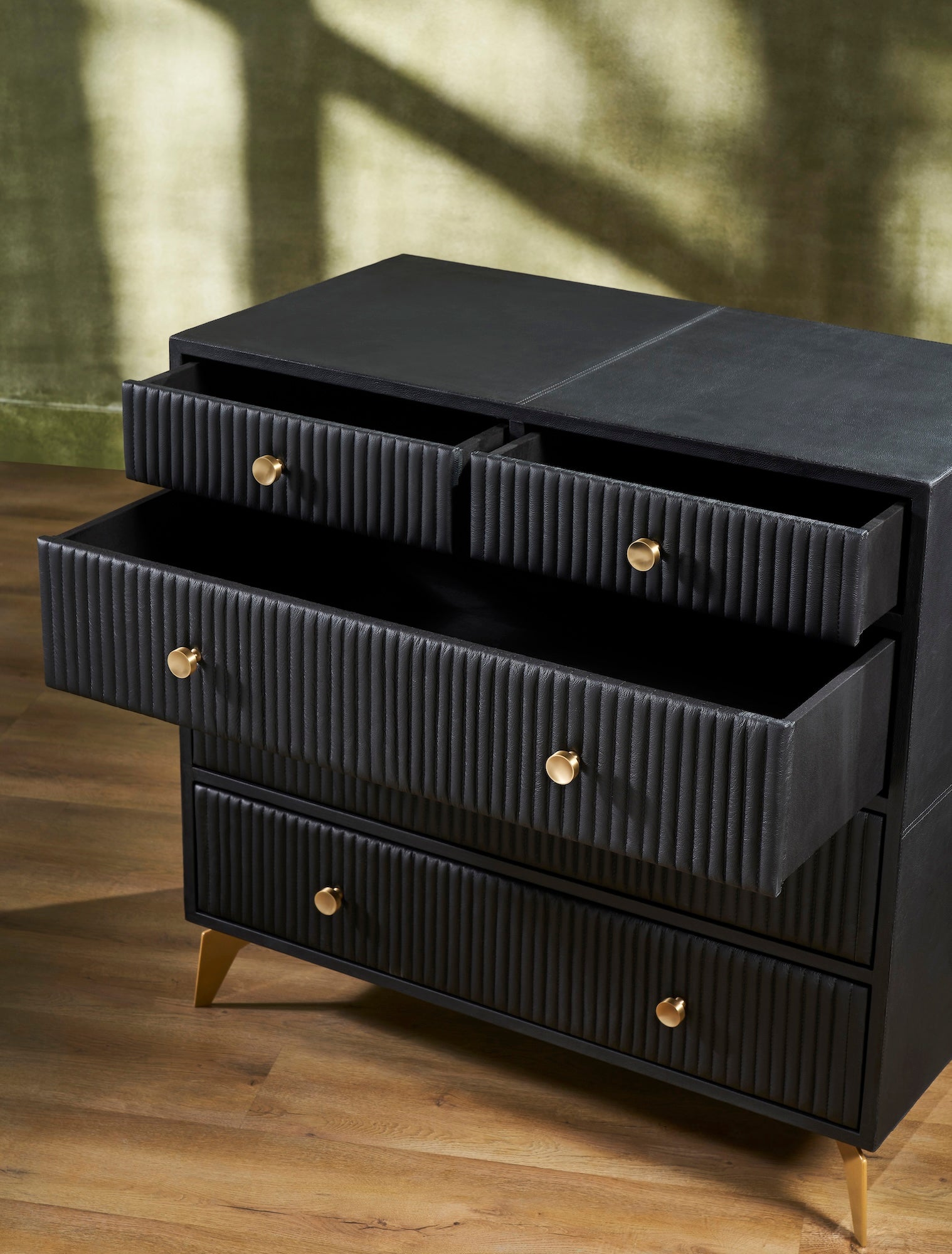 FN-5217-482036_4|Modern black leather chest of drawers with elegant fluted design, sleek gold hardware, and sturdy golden legs, perfect for luxury bedroom furniture.