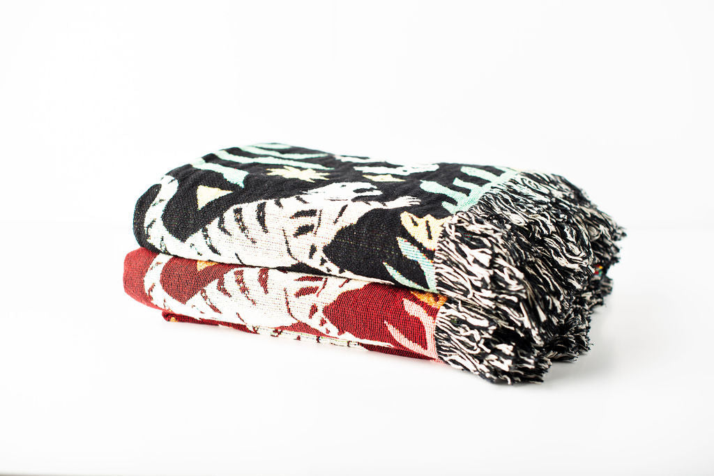 Leona tiger-patterned woven throw blankets stacked in Solstice and Verdant colorways