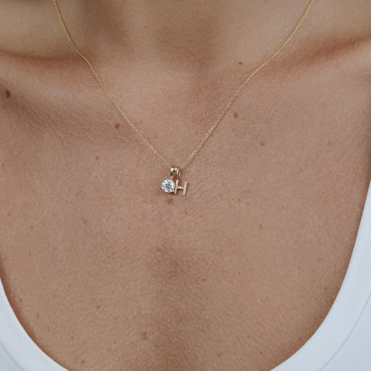 Close-up of a decellotage wearing a Diamond Letter Jumble on a Signature Cable Chain in yellow gold.