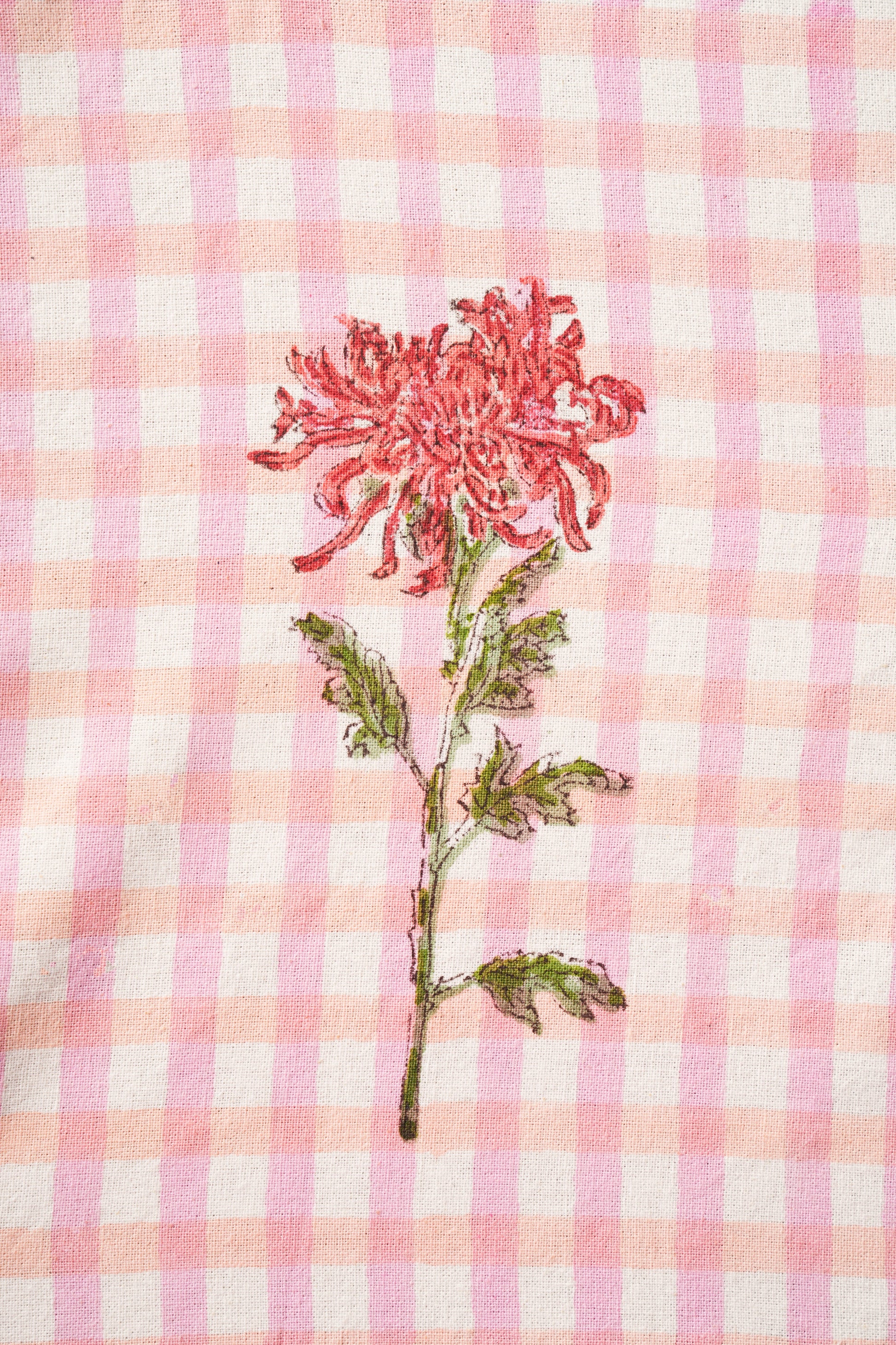Close-up of red dahlia flower embroidered on pink gingham fabric - Inner Child