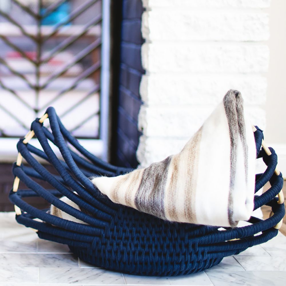 striped alpaca throw blanket in blue woven basket
