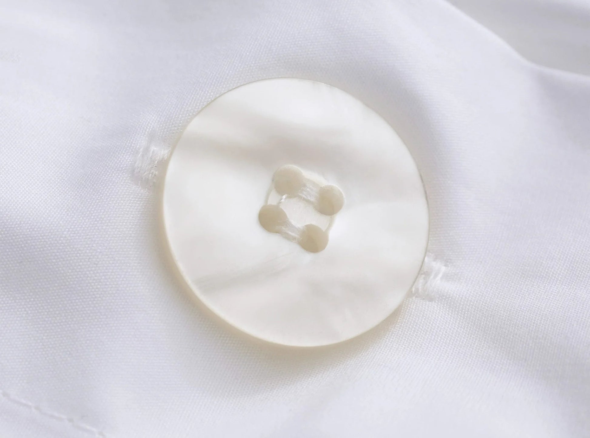 Close-up of button closure on white organic cotton percale duvet cover - quality construction
