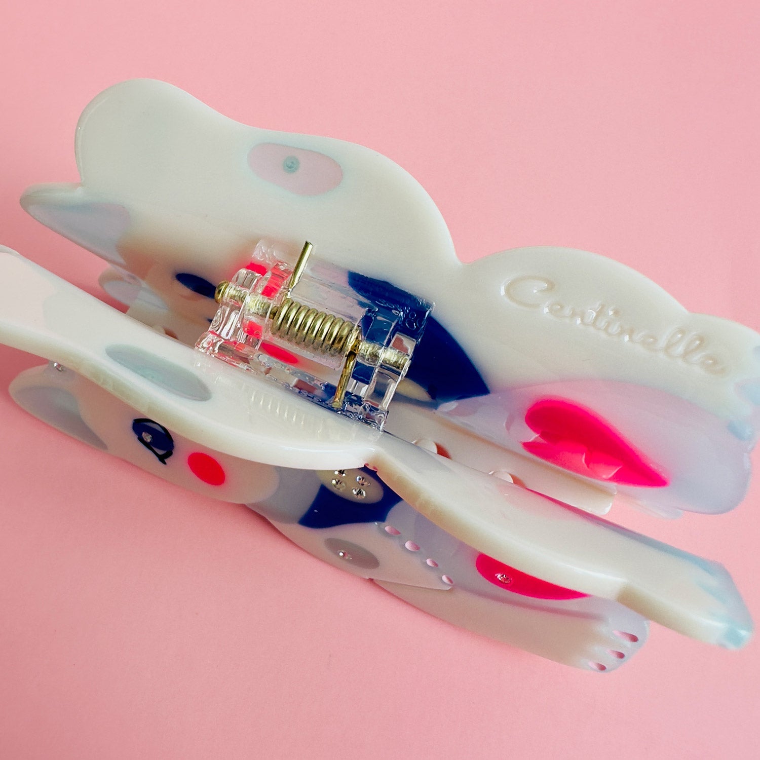 A maneki-neko white cat hair claw with a pink heart from Centinelle. Handmade on cellulose acetate, with splice technique, exquisite miniature details and crystals, that are tied directly to its value and make them unique and special. 