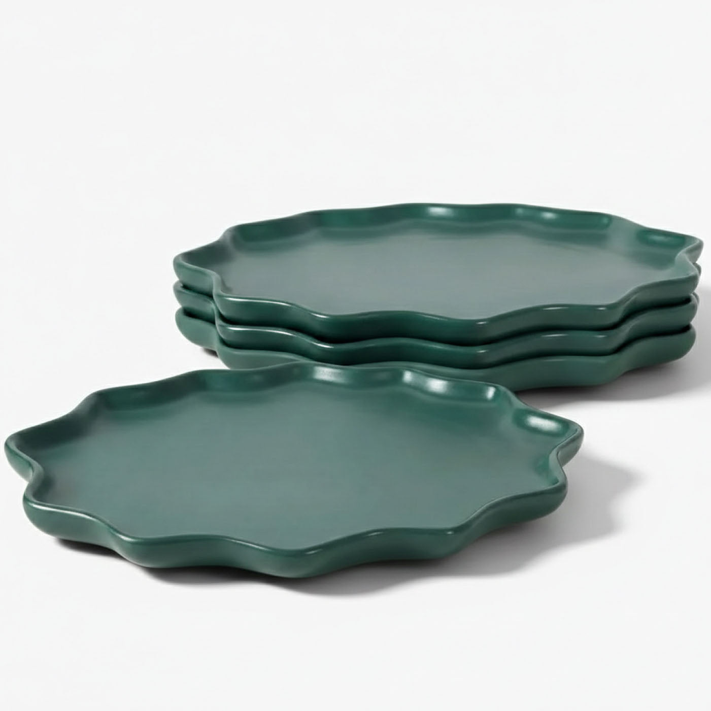 A 4-piece set of BosilunLife Forest Star dinner plates in a matte deep forest green finish. Crafted from recycled eco-clay, the plates feature a unique, organic starburst silhouette with a scalloped, wavy rim. The set is shown with three plates neatly stacked in the background and one plate in the foreground against a clean white background, highlighting a sustainable and nature-inspired tableware aesthetic.