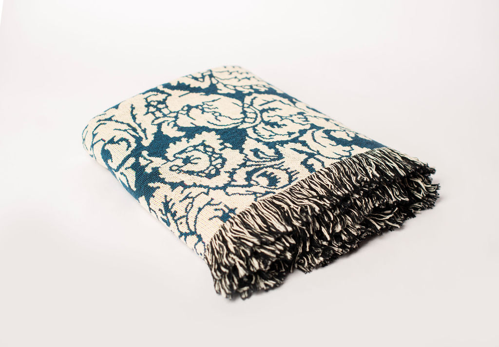 Folded Verona Cerulean floral woven cotton throw blanket shown from the side
