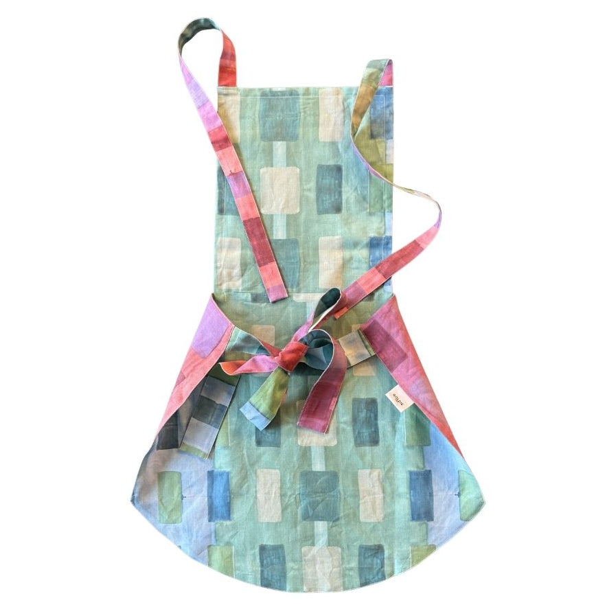 The Gemma Apron in Tapestry shown on model in kitchen setting - Goldie Home