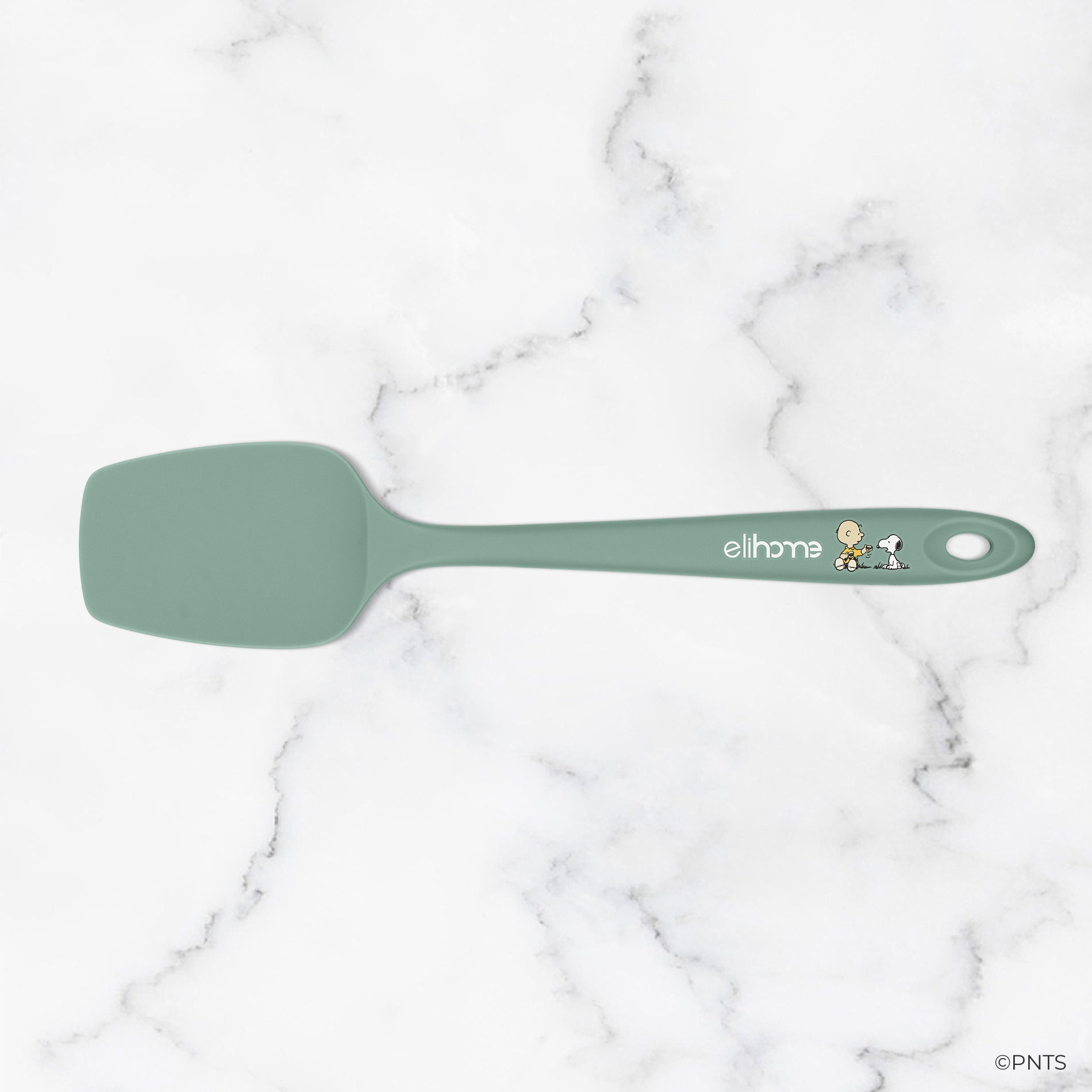 Green spatula with 'elihome' branding on a marble background