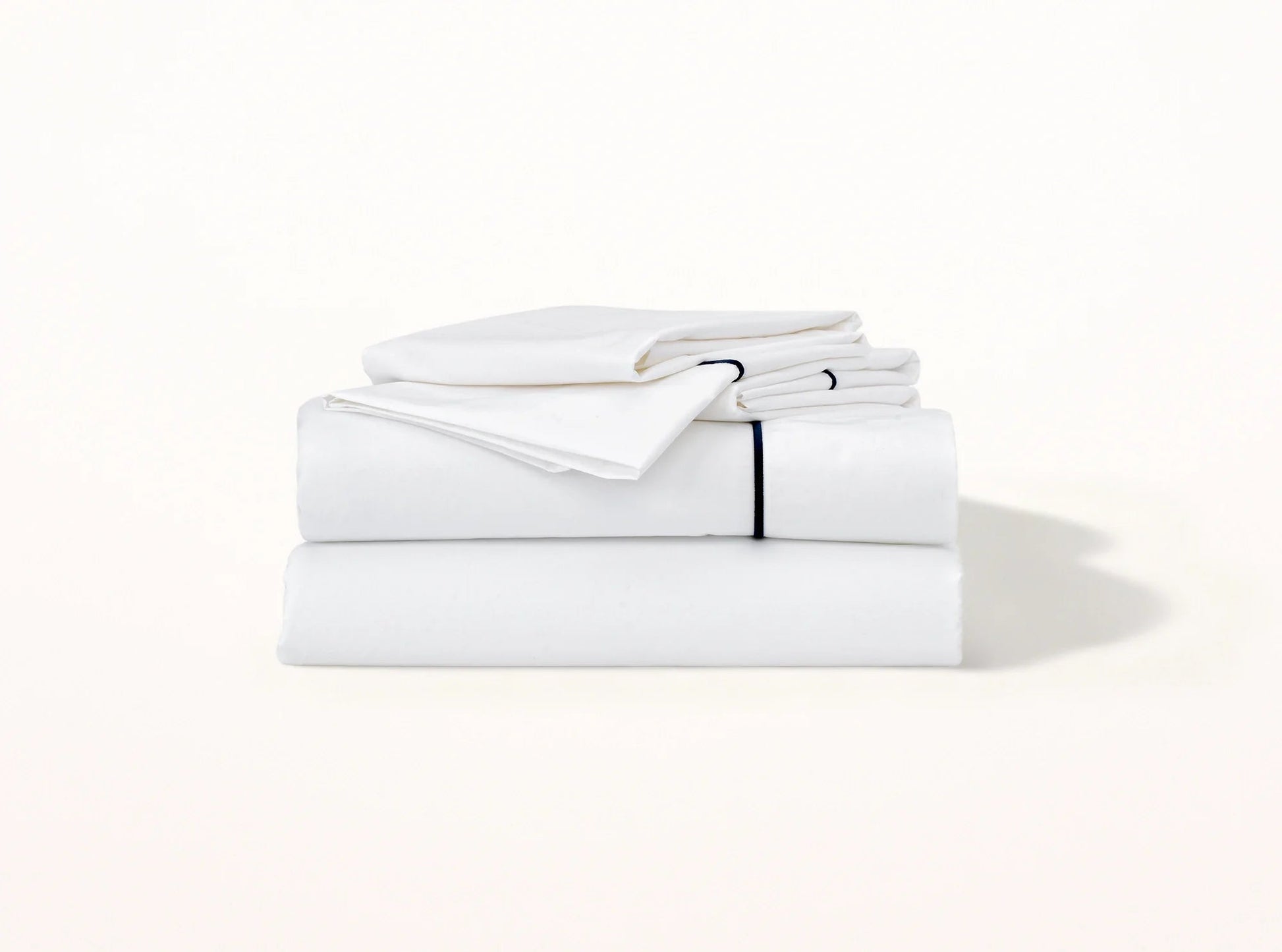 Organic cotton percale sheet set with navy blue embroidered detail on white - elegant contrast