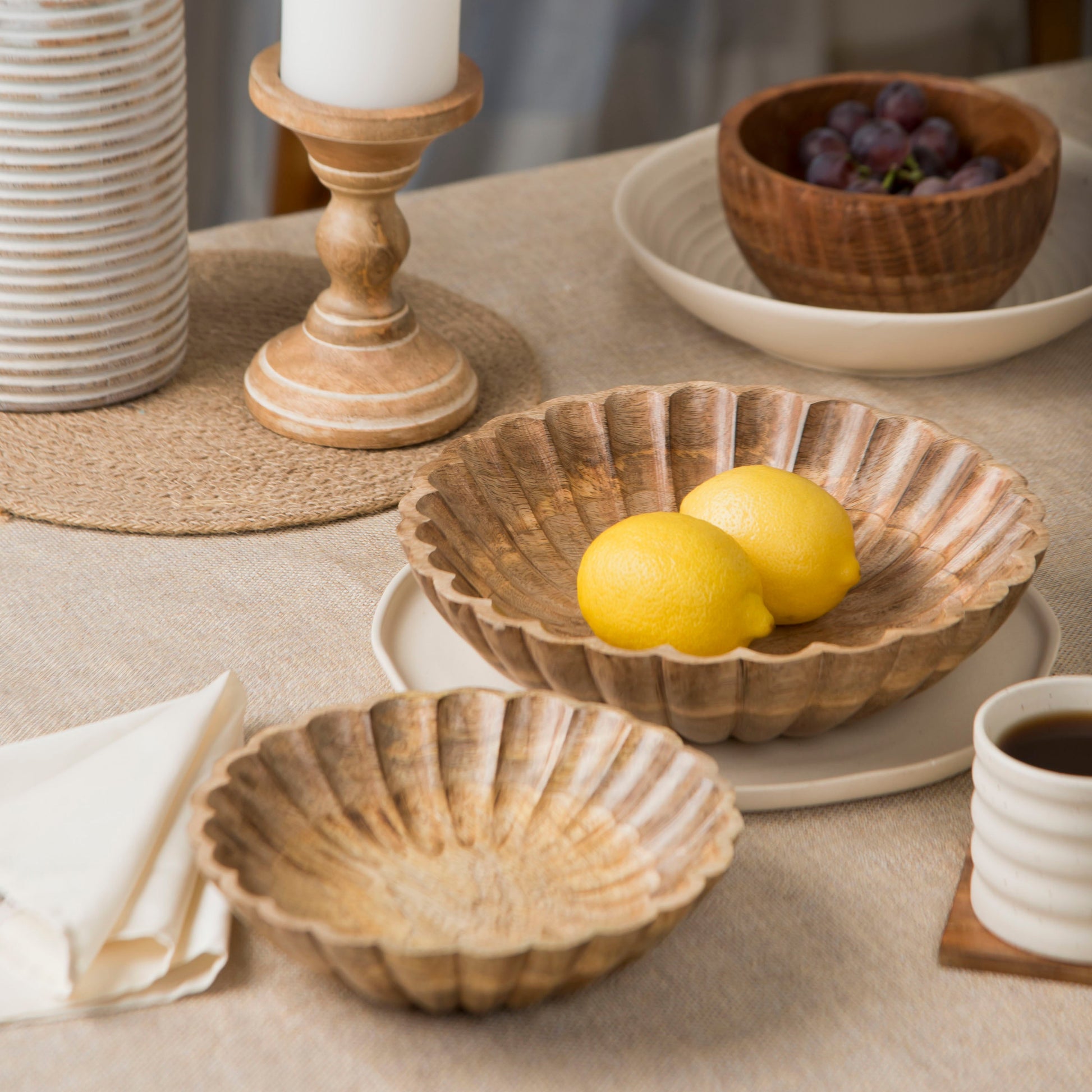 Scalloped wooden bowls styled with fruits on a dining table