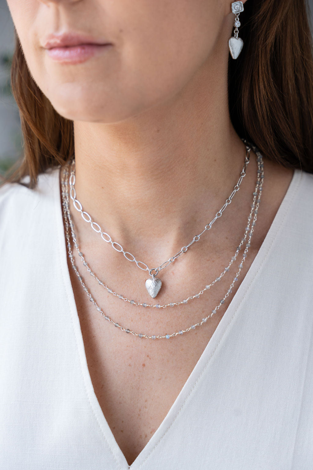 Silver heart charm necklace with elongated chain and brushed metal heart pendant